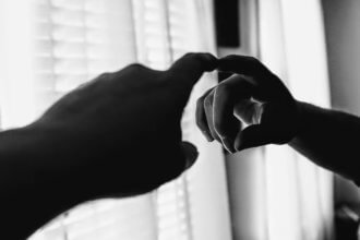 Black and white image of finger pointing at itself in the mirror.
