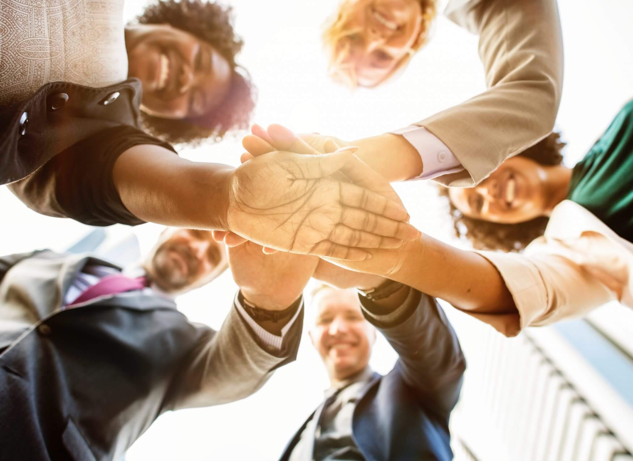 Group of people in a huddle with their hands together