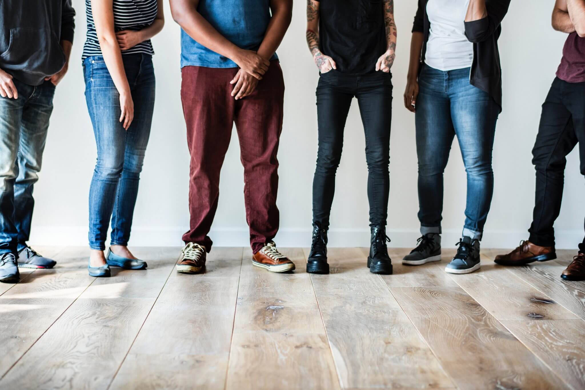 Young people standing in a row, the camera panned from the waist down.