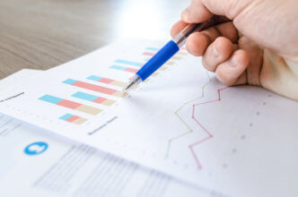 Man showing business graph on wood table