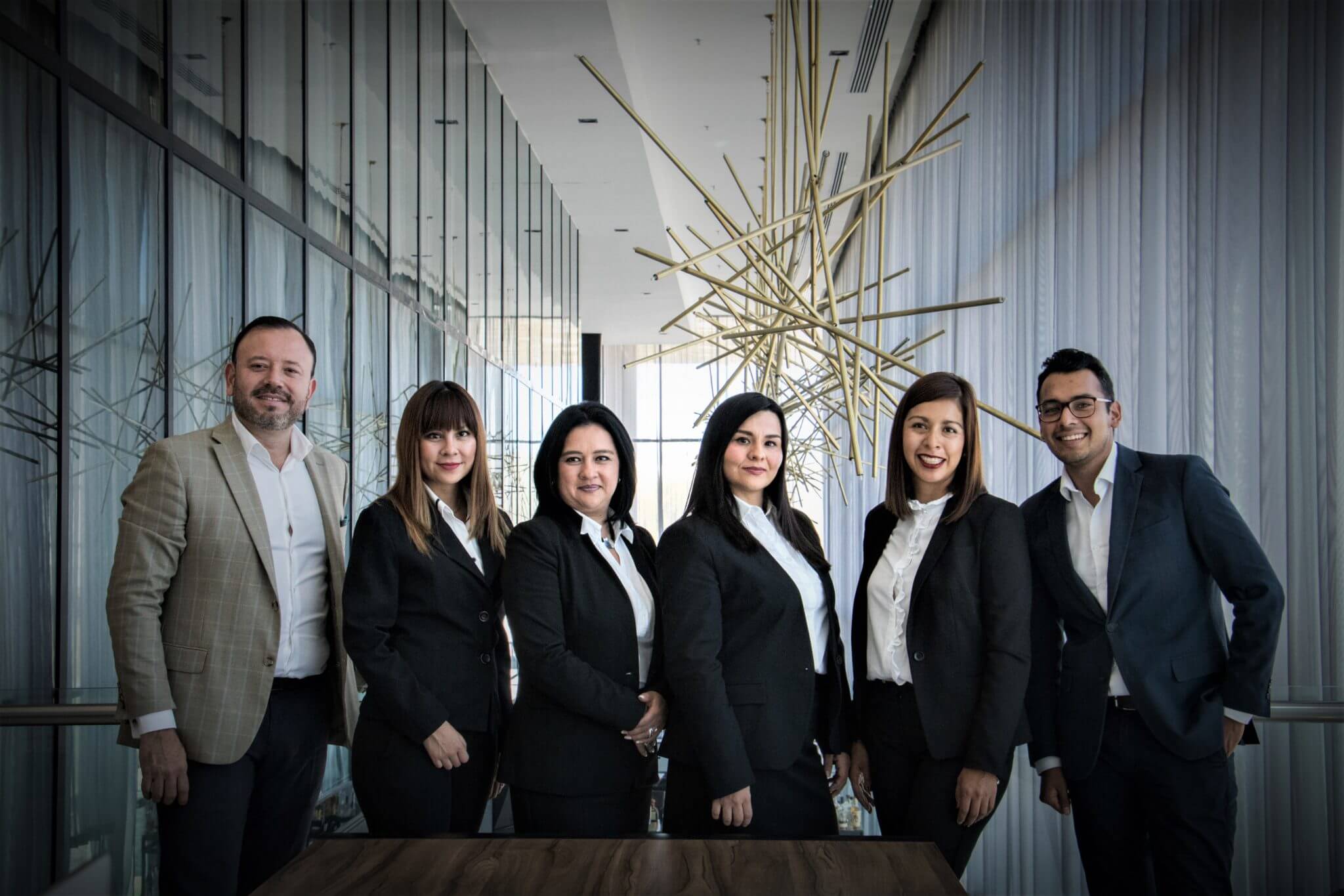 group of employees dressed in business attire standing and looking at the camera