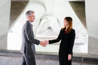 woman shaking hands with a man and smiling