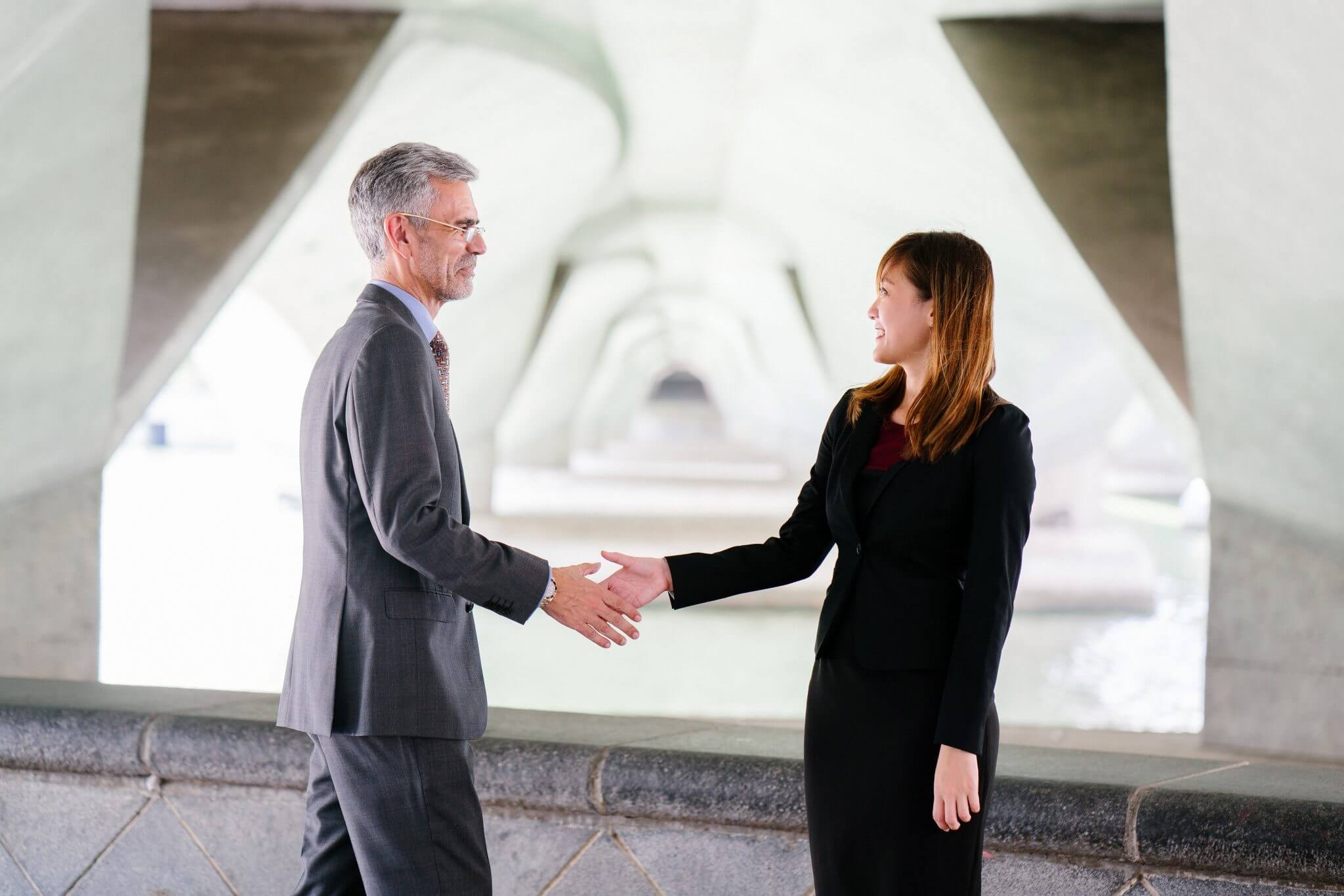 woman shaking hands with a man and smiling woman shaking hands with a man and smiling
