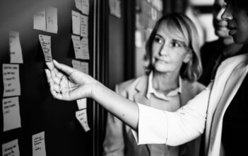 An employee showing her boss an idea on a whiteboard.