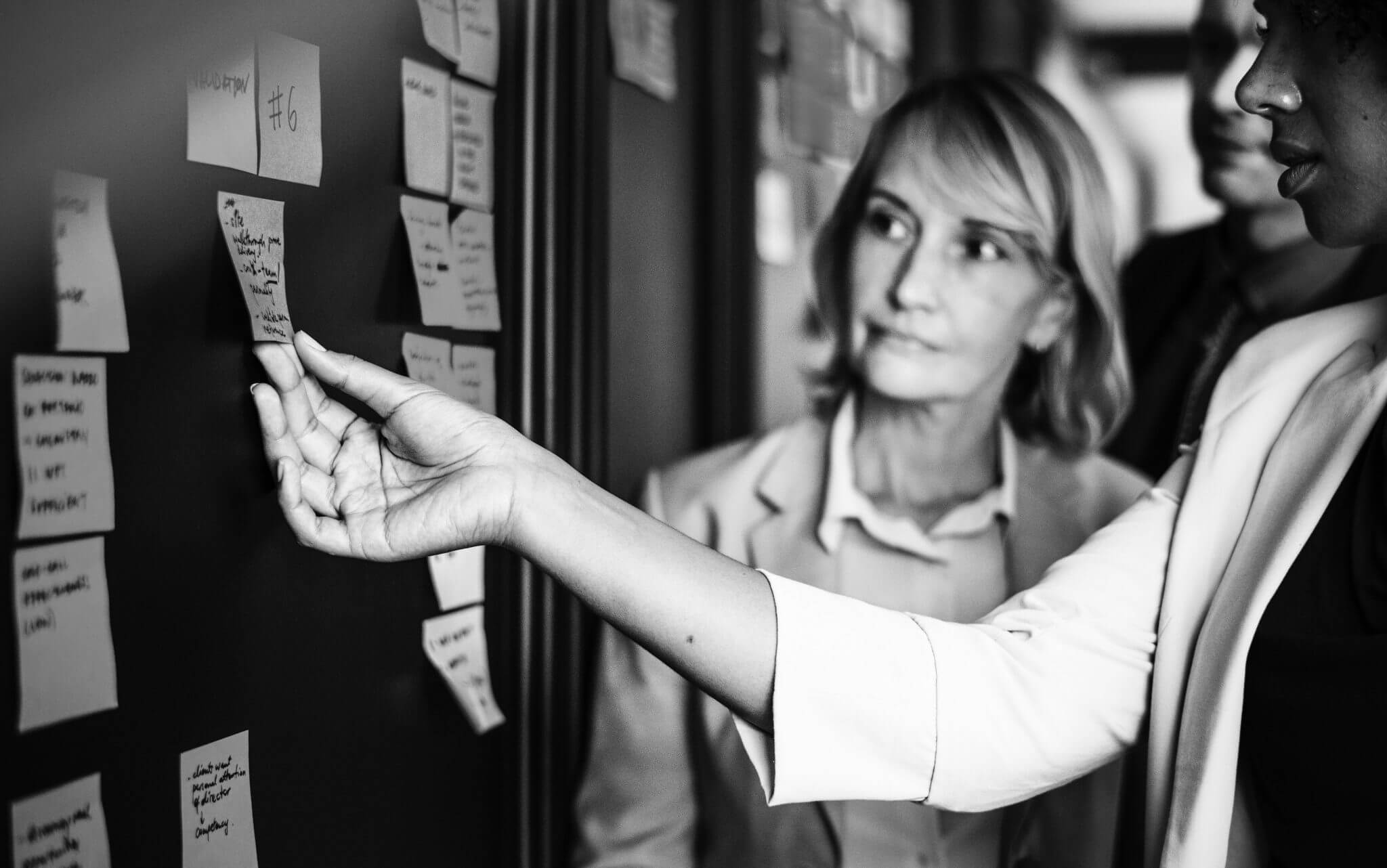 An employee showing her boss an idea on a whiteboard. An employee showing her boss an idea on a whiteboard.