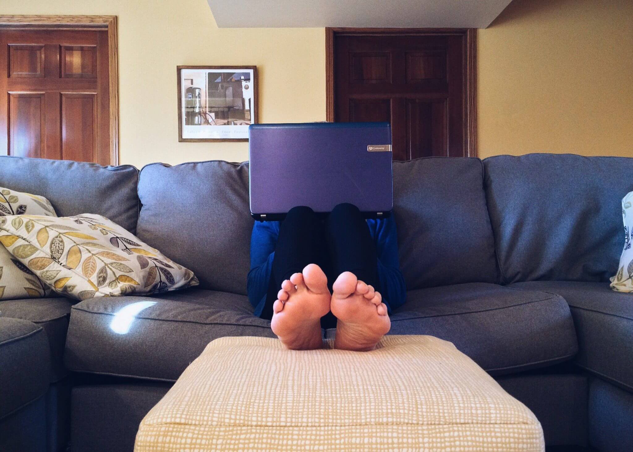 Person sitting on couch with laptop on their lap