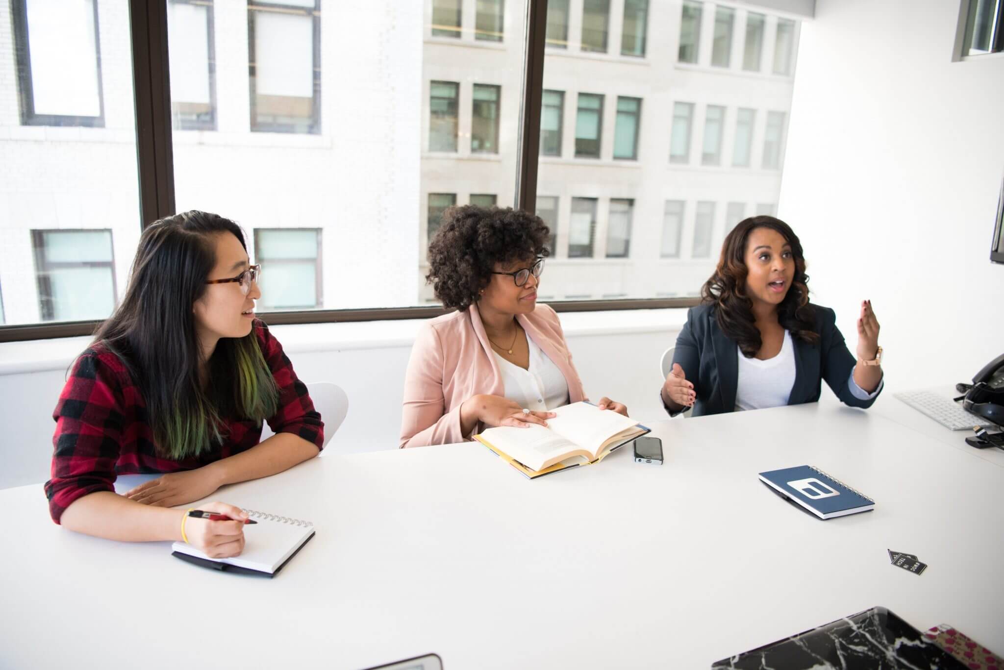 A group of employees sitting around a table discussing ideas and sharing.