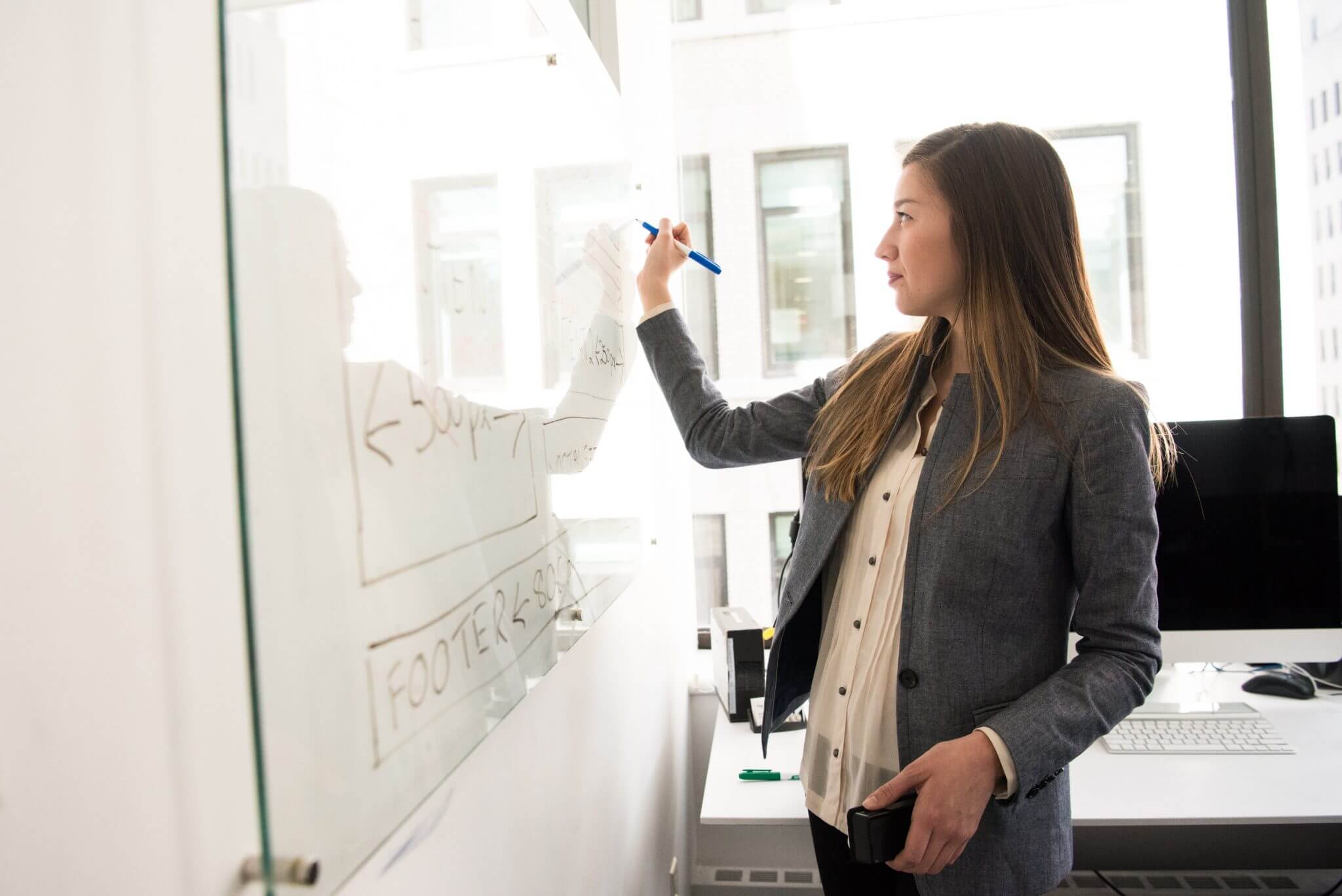 Woman standing at a white board writing