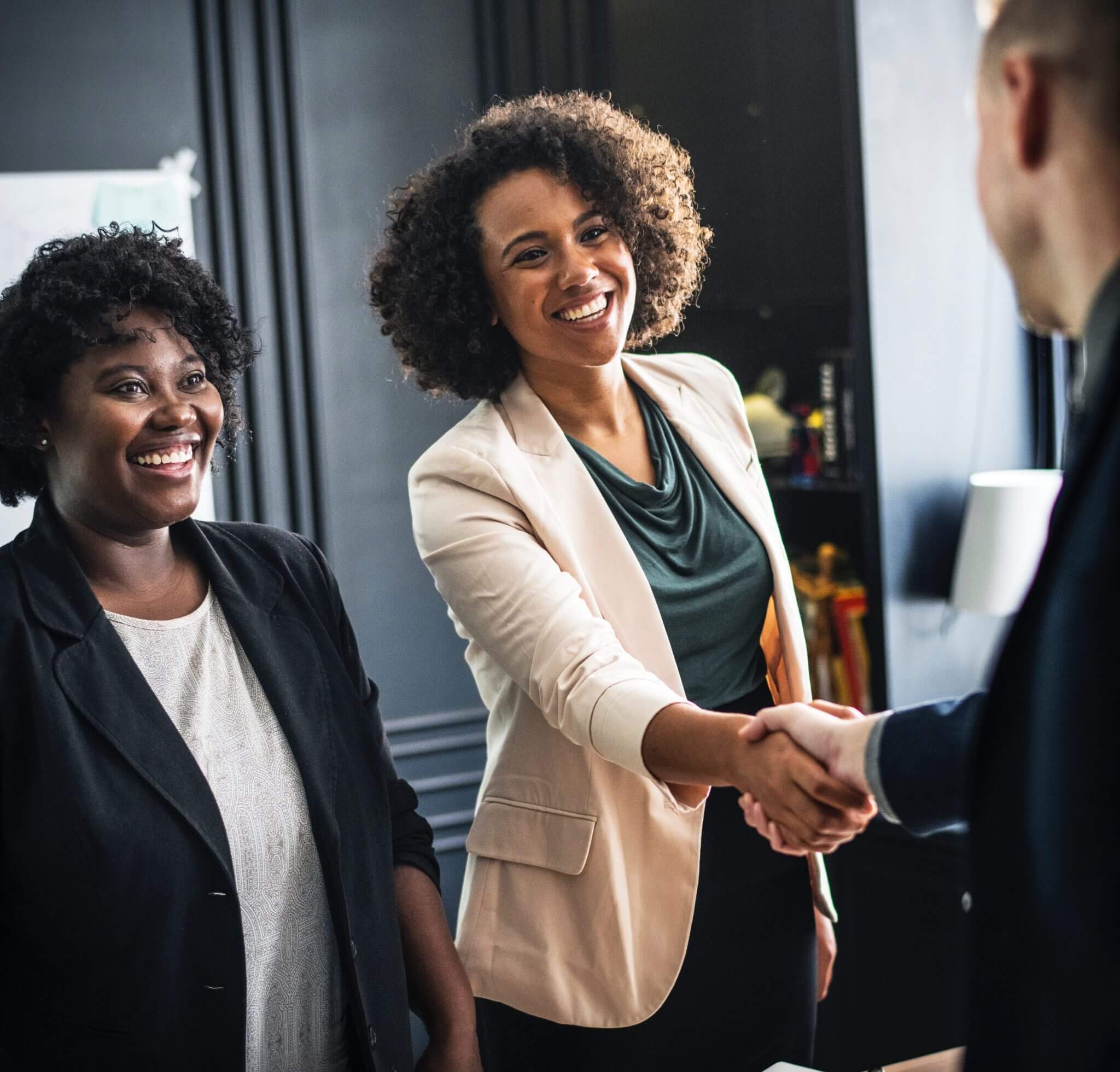 Woman shaking hands with a prospective employer during a first meeting interview.