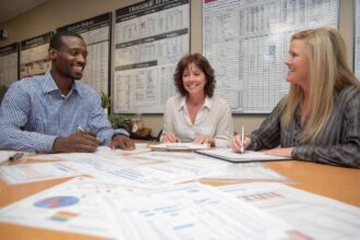 Hiring managers reviewing candidate job knowledge test reports in a meeting.
