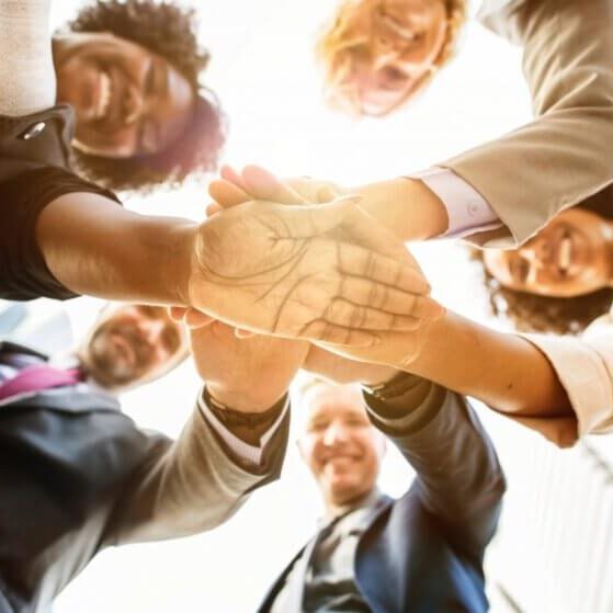Group of people in a huddle with their hands together