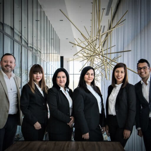 group of employees dressed in business attire standing and looking at the camera
