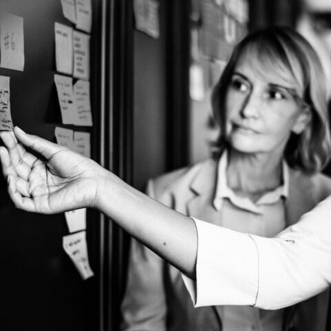 An employee showing her boss an idea on a whiteboard.