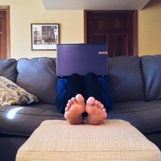 Person sitting on couch with laptop on their lap