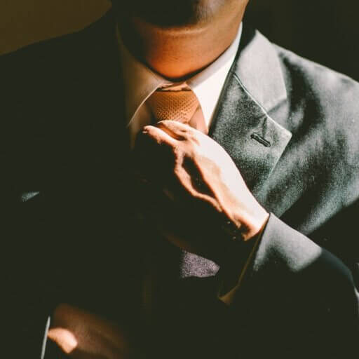 Man in a suit straightening his tie